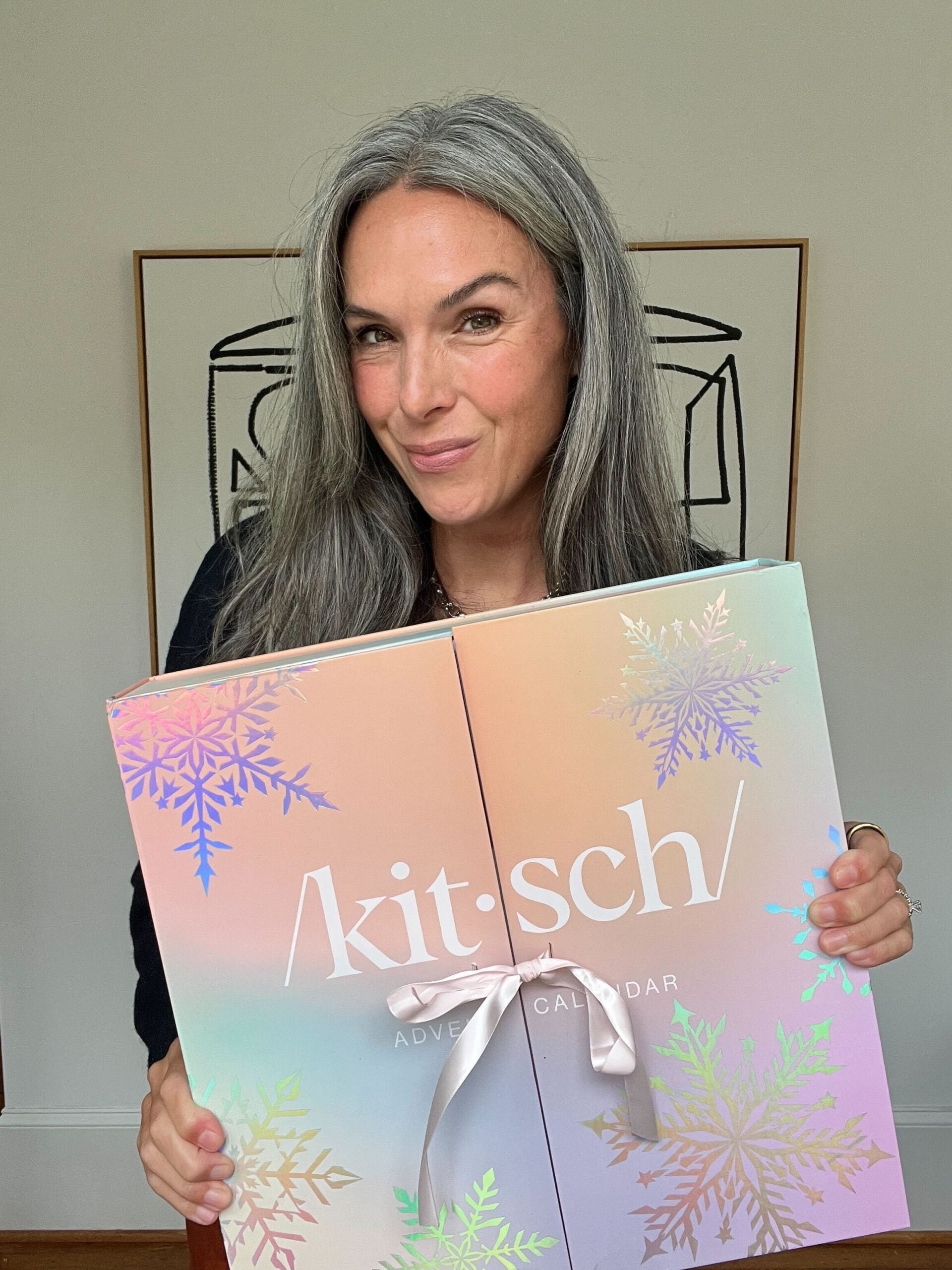 A woman holds up a large Advent calendar from Kitsch.
