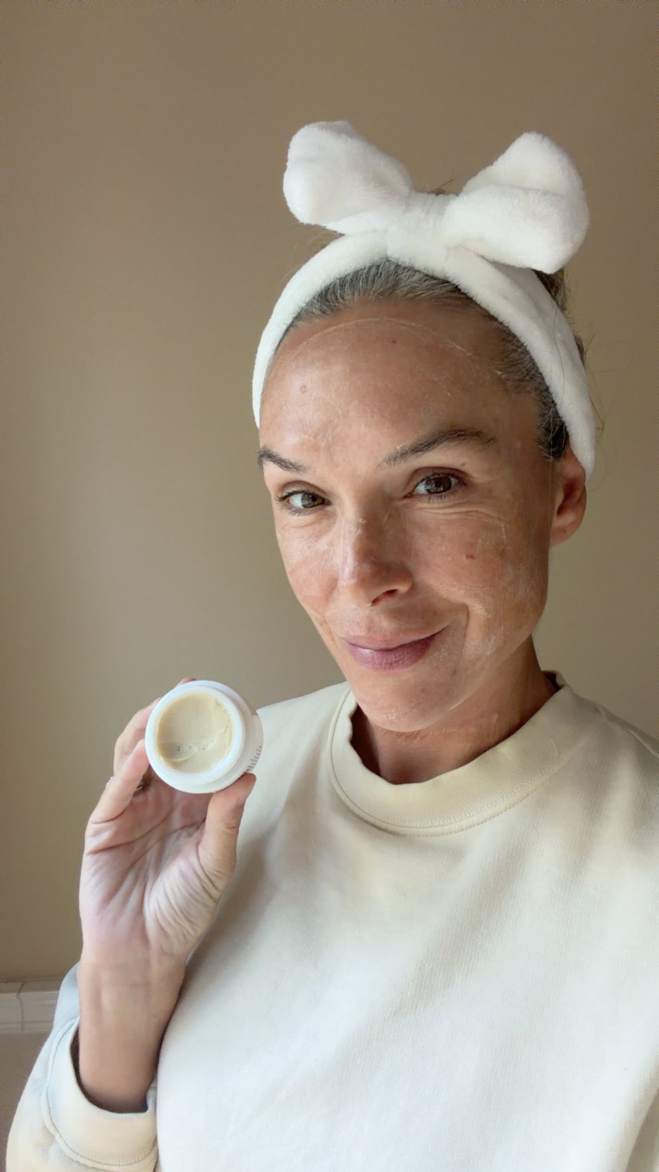 A smiling woman wearing a face mask and bow headband.